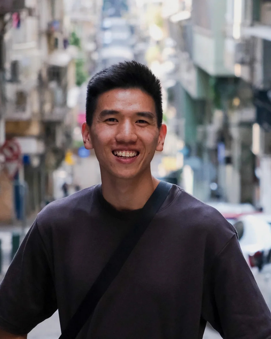 Eddy smiling on a narrow street