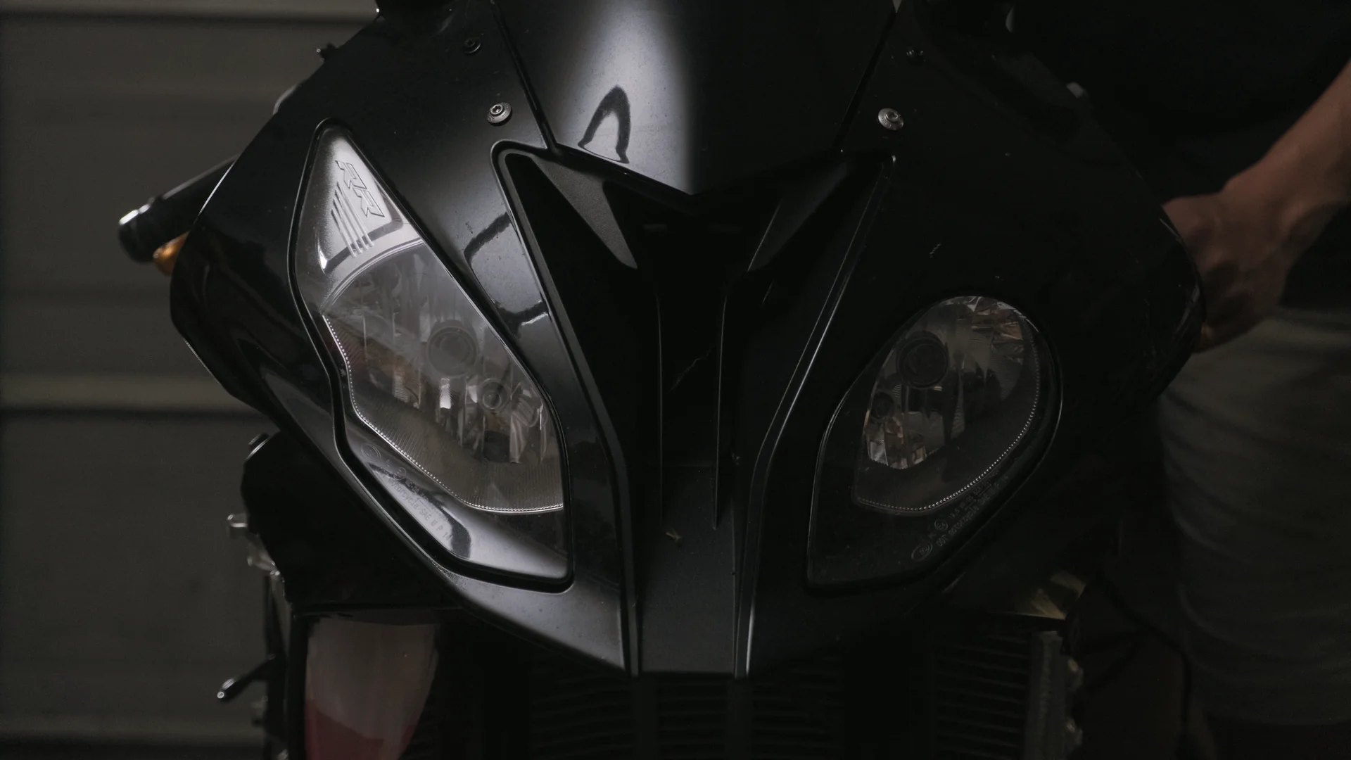 The nose of the S1000RR, headlights off, in a dark garage
